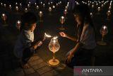 Dua anak umat Buddha menyalakan lilin saat mengikuti prosesi Lilin Kedamaian dalam rangkaian Pabajja Samanera Sementara 2024 di Perguruan Buddhi Dharma, Kota Tangerang, Banten, Sabtu (28/12/2024). Prosesi meditasi bersama dan ritual penyalaan lilin sebagai lambang perdamaian tersebut juga merupakan wujud bakti para umat kepada Sang Buddha. ANTARA/Sulthony Hasanuddin/gp