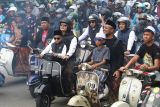 Sejumlah peserta mengendarai skuter Vespa saat kegiatan bertajuk Scooter Sarungan di Kediri, Jawa Timur, Minggu (29/12/2024). Touring skuter Vespa menempuh jarak 22 kilometer yang diikuti oleh sedikitnya tiga ribu peserta bersarung tersebut guna memperingati 100 tahun berdirinya pondok pesantren Al-Falah Ploso Kediri. Antara Jatim/Prasetia Fauzani/um