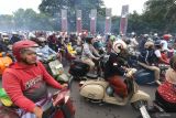 Sejumlah peserta mengendarai skuter Vespa saat kegiatan bertajuk Scooter Sarungan di Kediri, Jawa Timur, Minggu (29/12/2024). Touring skuter Vespa menempuh jarak 22 kilometer yang diikuti oleh sedikitnya tiga ribu peserta bersarung tersebut guna memperingati 100 tahun berdirinya pondok pesantren Al-Falah Ploso Kediri. Antara Jatim/Prasetia Fauzani/um