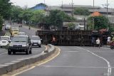 Warga melihat truk kontainer yang terguling di Flyover Trosobo, Taman, Sidoarjo, Jawa Timur, Minggu (29/12/2024). Kepala Korps Lalu Lintas Kepolisian Republik Indonesia (Kakorlantas Polri) Inspektur Jenderal Aan Suhanan merilis data kecelakaan lalu lintas pada tahun 2024 sebanyak 1.150.000 kecelakan dalam kurun waktu Januari-Desember 2024 dengan korban meninggal sebanyak 27 ribu jiwa. Antara Jatim/Umarul Faruq