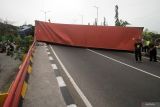 Warga melihat truk kontainer yang terguling di Flyover Trosobo, Taman, Sidoarjo, Jawa Timur, Minggu (29/12/2024). Kepala Korps Lalu Lintas Kepolisian Republik Indonesia (Kakorlantas Polri) Inspektur Jenderal Aan Suhanan merilis data kecelakaan lalu lintas pada tahun 2024 sebanyak 1.150.000 kecelakan dalam kurun waktu Januari-Desember 2024 dengan korban meninggal sebanyak 27 ribu jiwa. Antara Jatim/Umarul Faruq