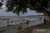 Sejumlah wisatawan bermain air saat mengunjungi Pantai Lagundi, Anyer, Kabupaten Serang, Banten, Minggu (29/12/2024). Pengelola pantai menuturkan pada H-2 Tahun Baru 2025 kunjungan wisatawan ke pantai tersebut mengalami penurunan cukup signifikan dari rata-rata sekitar 2.200 pengunjung saat musim liburan menjadi sekitar 1.350 pengunjung akibat dampak dari gelombang tinggi di wilayah perairan Selat Sunda. ANTARA FOTO/Angga Budhiyanto/gp