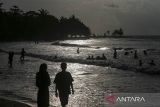 Sejumlah wisatawan bermain air saat mengunjungi Pantai Lagundi, Anyer, Kabupaten Serang, Banten, Minggu (29/12/2024). Pengelola pantai menuturkan pada H-2 Tahun Baru 2025 kunjungan wisatawan ke pantai tersebut mengalami penurunan cukup signifikan dari rata-rata sekitar 2.200 pengunjung saat musim liburan menjadi sekitar 1.350 pengunjung akibat dampak dari gelombang tinggi di wilayah perairan Selat Sunda. ANTARA FOTO/Angga Budhiyanto/gp