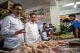 Menteri Perdagangan Budi Santoso (kiri) didamping Pj Gubernur Jawa Barat Bey Triadi Machmudin (kedua kiri) berbincang dengan pedagang daging ayam saat kunjungan kerja di pasar Tagog Padalarang, Kabupaten Bandung Barat, Jawa Barat, Senin (23/12/2024). Mendag melakukan kunjungan untuk meninjau ketersediaan pasokan dan harga bahan pokok di pasar tradisional jelang Natal 2024 dan Tahun Baru 2025. ANTARA FOTO/Abdan Syakura/agr