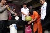 Tersangka ET di bawah pengawasan polisi memeragakan cara menyuling bahan bakar gas (elpiji) subsidi dari tabung ukuran 3 kg ke tabung 12 kg saat gelar ungkap kasus/perkara di Maolres Tulungagung, Tulungagung, Jawa Timur, Senin (30/12/2024). Tindakan ilegal itu dilakukan ET sejak Juni 2024 dengan memindahkan gas dari 60 tabung elpiji bersubsidi ukuran 3 kg ke 20 tabung 12 kg setiap pekannya, lalu dijual ke konsumen dengan harga nonsubsidi sebesar Rp150 ribu hingga Rp160 ribu lebih murah dibanding harga pasaran yang mencapai Rp190 ribu/tabung ukuran 12 kg. Antara Jatim/Destyan Sujarwoko/um