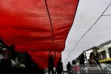 Sejumlah mahasiswa membentangkan bendera Merah Putih saat melakukan aksi longmarch menuju kantor Satpol PP Kota Serang di Kota Serang, Banten, Senin (30/12/2024). Dalam aksi tersebut mereka menuntut Pemerintah Kota Serang untuk menutup tempat hiburan malam yang beroperasi di wilayah Kota Serang karena diduga telah menyalahi aturan. ANTARA FOTO/Putra M. Akbar/gp