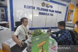 Petugas melayani warga wajib pajak di Kantor Pelayanan Pajak (KPP) Pratama Bengkulu Dua, Kota Bengkulu, Bengkulu, Senin (30/12/2024). KPP Pratama II Bengkulu mencatat realisasi pemadanan Nomor Pokok Wajib Pajak (NPWP) menjadi Nomor Induk Kependudukan (NIK) periode Januari-Desember 2024 mencapai 489.956 orang atau 86,3 persen dari total wajib pajak di Provinsi tersebut sebanyak 567.690 orang, sedangkan 77.734 orang belum melakukan perubahan NPWP ke NIK. ANTARA FOTO/Muhammad Izfaldi