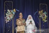 Pasangan pengantin tuna netra menunjukan buku nikah bersiap saat nikah massal tuna netra se-Priangan Timur di Gedung Aisyah, Kota Tasikmalaya, Jawa Barat, Selasa (31/12/2024). Pernikahan massal gratis yang diikuti lima pasangan pengantin tuna netra itu untuk membantu para penyandang disabilitas yang tidak mampu secara ekonomi dalam mendapatkan legalitas hukum negara. ANTARA FOTO/Adeng Bustomi/agr