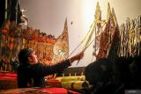 Dalang muda Ki Badar Alam memainkan wayang kulit saat pentas di Lengkong, Nganjuk, Jawa Timur, Rabu (1/1/2025). Pagelaran wayang kulit yang berjudul Sirnaning Memala Ngalengka itu digelar pemerintah setempat guna melestarikan warisan kebudayaan lokal dan menyambut tahun baru 2025. Antara Jatim/Muhammad Mada/um