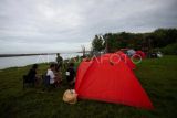 Wisatawan berkemah di Camping Ground Laguna Pantai Baros, Bantul, D.I Yogyakarta, Rabu (1/1/2025). Wisata Laguna Pantai Baros menjadi salah satu destinasi wisata favorit warga Yogyakarta dan daerah lain untuk beribur saat tahun baru. ANTARA FOTO/Andreas Fitri Atmoko/tom.