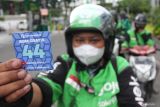 Pengemudi ojek daring menunjukkan kupon saat antre mendapatkan bahan bakar minyak (BBM) gratis di salah satu SPBU di Jalan Pemuda, Surabaya, Jawa Timur, Jumat (3/1/2025). Sebanyak 150 pengemudi ojek daring mendapatkan pemberian BBM gratis senilai Rp20 ribu dari seorang warga bernama Rida (52) bersama sejumlah donatur lainnya yang bertujuan untuk meringankan beban ekonomi para pengemudi ojek daring. Antara Jatim/Didik Suhartono/um