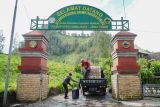 Warga mengisi air didepan gerbang masuk pendakian Gunung Semeru di Desa Ranupani, Lumajang, Jawa Timur, Jumat (3/1/2025). Balai Besar Taman Nasional Bromo Tengger Semeru menghentikan sementara kegiatan pendakian Gunung Semeru sejak tanggal 2 hingga 19 Januari 2025 sebagai antisipasi dari ancaman bencana alam yang dipicu oleh cuaca ekstrim. ANTARA Jatim/Irfan Sumanjaya/mas.