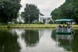 Pengunjung berada di dalam perahu wahana Tutur Danau Boat Ride di Kebun Raya Bogor, Jawa Barat, Sabtu (4/1/2025). Wahana tersebut menawarkan sensasi berkeliling Danau Gunting dengan menaiki perahu dan menikmati keindahan alam Kebun Raya Bogor serta pemandangan Istana Kepresidenan Bogor. ANTARA FOTO/Arif Firmansyah/agr