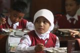 Siswa membuka kotak berisi makanan dalam pelaksanaan Program Makan Bergizi Gratis (MBG) di SDN 1 Tamanharjo, Singosari, Malang, Jawa Timur, Senin (6/1/2025). Pelaksanaan perdana Program  Makan Bergizi Gratis (MBG) perdana tersebut dilaksanakan pihak TNI AU dengan menyasar 27 sekolah di sekitar kawasan Lanud Abdul Rahman Saleh dengan jumlah 4.005 porsi per hari. Antara Jatim/Ari Bowo Sucipto/um