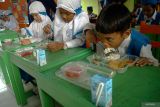 Siswa menyantap menu makanan yang diberikan guru melalui program Makan Bergizi Gratis (MBG) di TK Al-Azhar, Tulungagung, Jawa Timur, Senin (6/1/2025). Pada hari pertama pelaksanaan program MBG di Tulungagung ini pemerintah melalui Badan Gizi Nasional (BGN) sedianya membagikan 3.480 porsi makan untuk 3.480 siswa di 25 sekolah namun akhirnya hanya terealisasi sebanyak 1.386 porsi untuk 1.386 siswa di enam sekolah mulai enjang PAUD, TK, SD, SMP hingga SMA/SMK karena keterbatasan tenaga memasak. Antara Jatim/Destyan Sujarwoko/um