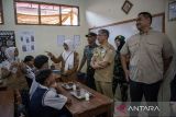 Menteri Pemuda dan Olahraga (Menpora) Dito Ariotedjo (kanan) bersama Pj Wali Kota Cimahi Dicky Saromi (kedua kanan) meninjau pelaksanaan program makan bergizi gratis (MBG) di SMPN 12 Cimahi, Kota Cimahi, Jawa Barat, Senin (6/1/2025). Dalam kunjungan kerja tersebut Menpora Dito Ariotedjo dan Wamenpora Taufik Hidayat berkesempatan untuk meninjau proses pengemasan menu makan bergizi gratis (MBG) di Satuan Pelayanan Pemenuhan Gizi serta pelaksanaan program makan bergizi gratis di sekolah. ANTARA FOTO/Abdan Syakura/agr