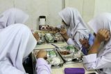 Siswa menyantap makanan bergizi gratis di SMA Muhammadiyah 2 Sidoarjo, Jawa Timur, Senin (6/1/2025). Pelaksanaan perdana Program Makan Bergizi Gratis (MBG) dilakukan secara bertahap di sejumlah sekolah di Sidoarjo mencakup jenjang TK, SD, SMP, hingga SMA/SMK sederajat hingga Pos Pelayanan Terpadu (Posyandu) dengan total 6.003 porsi paket makanan. Antara Jatim/Umarul Faruq