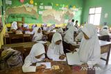 Sejumlah siswa mengikuti kegiatan belajar mengajar di SDN Teranggana, Kasemen, Kota Serang, Banten, Senin (6/1/2025). Menurut pihak sekolah, terdapat tiga kelas mengalami kerusakan berat pada bagian tembok bangunan yang rawan roboh dan lantai ambles, sehingga kegiatan belajar mengajar harus dialihkan ke ruangan laboratorium dan mushola. ANTARA FOTO/Putra M. Akbar/gp