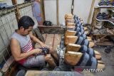 Pekerja menyelesaikan produksi sepatu di sentra produksi sepatu Cibaduyut, Bandung, Jawa Barat, Selasa (7/1/2025). Asosiasi Persepatuan Indonesia (Aprisindo) menyatakan, pelemahan nilai tukar rupiah terhadap dollar AS dalam beberapa waktu terakhir berpotensi ikut mendongkrak biaya produksi industri alas kaki nasional sebanyak dua persen sedangkan kebutuhan bahan baku yang harus dipenuhi dari impor untuk produksi alas kaki mencapai 50 persen. ANTARA FOTO/Raisan Al Farisi/agr
