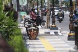 Pengendara sepeda motor melintas di jalan Soekarno-Hatta yang telah dibangun trotoar di Kediri, Jawa Timur, Senin (6/1/2025). Pemerintah daerah setempat melakukan revitalisasi trotoar di jalan Soekarno-Hatta sepanjang 1,375 kilometer pada sisi kanan dan 1,425 kilometer pada sisi kiri serta memasang fasilitas lampu jalan dengan hiasan berbentuk lidah api ikonik Kediri, kursi pedestrian, dan tempat sampah dengan anggaran mencapai Rp8 miliar. ANTARA Jatim/Prasetia Fauzani/mas.