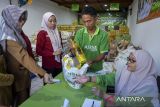 Petugas melayani pembeli di Warung Inflasi, Pasar Lama Kota Serang, Banten, Selasa (7/1/2025). Pemerintah Kota Serang bekerja sama dengan Badan Usaha Milik Daerah (BUMD) Provinsi Banten menghadirkan Warung Inflasi yang menjual kebutuhan bahan pokok seperti beras, minyak goreng, tepung terigu dan gula dibawah harga pasar sebagai upaya menjaga stabilitas harga. ANTARA FOTO/Putra M. Akbar/gp