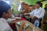 Menteri Komunikasi dan Digital Meutya Hafid (kanan) berbincang dengan seorang siswa saat meninjau pelaksanaan Program Makan Bergizi Gratis di SDN Cilangkap 5, Depok, Jawa Barat, Senin (6/1/2025). Pemerintah resmi memulai Program Makan Bergizi Gratis yang dilaksanakan serentak di 26 Provinsi di Indonesia. ANTARA FOTO/Yulius Satria Wijaya/nz.