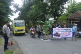 Warga melintasi jalan provinsi yang rusak ditanami pohon pisang di Kecamatan Kencong, Jember, Jawa Timur, Rabu (8/1/2025). Aksi penanaman pohon pisang sejauh 10 kilometer di jalan Jember-Lumajang itu sebagai bentuk protes warga karena rusaknya jalan antar kabupaten akibat dilewati truk over dimension overload (ODOL/dimensi dan muatan berlebih). Antara Jatim/Seno/um