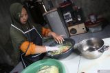 Devi Susanti (42) memasukkan kulit ikan patin kedalam tepung sebelum digoreng di Desa Jogoroto, Kecamatan Jogoroto, Kabupaten Jombang, Jawa Timur, Rabu (8/1/2025). Usaha rumahan kerupuk ikan patin yang digeluti ibu rumah tangga di Jombang, setelah mendapat pelatihan pengolahan ikan dari Dinas Perikanan Provinsi Jatim tersebut dalam sehari bisa memproduksi lima kilogram dan dijual mulai Rp12 ribu kemasan 45 gram hingga Rp25 ribu untuk kemasan 150 gram. ANTARA Jatim/Syaiful Arif/mas.