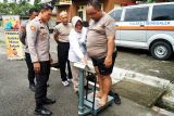 Wakapolres Trenggalek, Kompol Herlinarto (kiri) memantau hasil timbangan badan anggotanya yang ikut program penurunan berat badan atau indeks massa tubuh di Stadion Menak Sopal, Trenggalek, Jawa Timur, Rabu (8/1/2025). Sebanyak 60 personel polisi yang mengalami obesitas (polisi gendut) diwajibkan mengikuti program penurunan berat badan dengan olahraga ketat serta mengatur pola makan hingga mencapai berat badan ideal. Antara Jatim/Destyan Sujarwoko/um