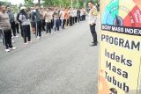 Wakapolres Trenggalek, Kompol Herlinarto (kanan) memberi pengarahan kepada anggotanya yang mengikuti program penurunan berat badan atau indeks massa tubuh di Stadion Menak Sopal, Trenggalek, Jawa Timur, Rabu (8/1/2025). Sebanyak 60 personel polisi yang mengalami obesitas (polisi gendut) diwajibkan mengikuti program penurunan berat badan dengan olahraga ketat serta mengatur pola makan hingga mencapai berat badan ideal. Antara Jatim/Destyan Sujarwoko/um