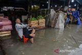 Pedagang melihat kondisi banjir di Pasar Induk Rau, Kota Serang, Banten, Kamis (9/1/2025). Tingginya intensitas hujan yang mengguyur wilayah Serang pada Kamis pagi dan saluran drainase yang tersumbat sampah membuat pasar tersebut terendam banjir dengan ketinggian berkisar 30-60 cm. ANTARA FOTO/Putra M. Akbar/gp