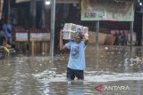 Pedagang melihat kondisi banjir di Pasar Induk Rau, Kota Serang, Banten, Kamis (9/1/2025). Tingginya intensitas hujan yang mengguyur wilayah Serang pada Kamis pagi dan saluran drainase yang tersumbat sampah membuat pasar tersebut terendam banjir dengan ketinggian berkisar 30-60 cm. ANTARA FOTO/Putra M. Akbar/gp