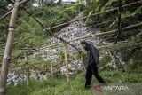 Warga berjalan di dekat tempat pembuangan sampah (TPS) ilegal di Gudangkahuripan, Lembang, Kabupaten Bandung Barat, Jawa Barat, Rabu (8/1/2025). Warga setempat mengeluhkan keberadaan TPS yang diduga tidak memiliki izin tersebut karena menimbulkan aroma tidak sedap dan mencemari lingkungan sekitar. ANTARA FOTO/Abdan Syakura/agr