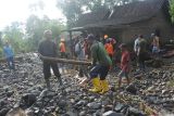 Sejumlah relawan membersihkan material kayu dampak banjir bandang di Desa Gunungsari, Maesan, Bondowoso, Jawa Timur, Jumat (10/1/2025). Bencana banjir bandang yang terjadi, Kamis (9/1) malam tersebut mengakibatkan 12 unit rumah warga rusak, dan 30 kepala keluarga atau 200-an jiwa terdampak. Antara Jatim/Seno/mas.