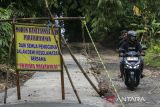 Pengendara sepeda motor melintasi jalan rusak di Kelurahan Kadomas, Kabupaten Pandeglang, Banten, Sabtu (11/1/2025). Warga setempat berinisiatif secara swadaya memperbaiki jalan penghubung antarkabupaten Pandeglang dan Lebak yang rusak selama sekitar 25 tahun itu tanpa adanya bantuan dari pemerintah setempat. ANTARA FOTO/Angga Budhiyanto/gp