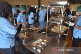 Sejumlah pekerja menyiapkan makanan bergizi gratis di Puri Mandalika, Cimahpar, Kota Bogor, Jawa Barat, Senin (13/01/2025). Badan Komunikasi Nasional Desa se-Indonesia (BKNDI) bekerja sama dengan sejumlah perusahaan swasta nasional yang mendukung program Makan Bergizi Gratis (MBG) memulai uji coba pemberian makanan bergizi gratis sebanyak 1500 porsi paket yang dibagikan untuk lima Sekolah Dasar Negeri di wilayah Cimahpar, Kota Bogor. (ANTARA FOTO/Arif Firmansyah).