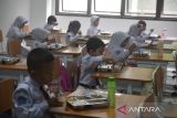 Sejumlah siswa menyantap makan bergizi gratis di SDN Cimahpar 3, Kota Bogor, Jawa Barat, Senin (13/01/2025). Badan Komunikasi Nasional Desa se-Indonesia (BKNDI) bekerja sama dengan sejumlah perusahaan swasta nasional yang mendukung program Makan Bergizi Gratis (MBG) memulai uji coba pemberian makanan bergizi gratis sebanyak 1500 porsi paket yang dibagikan untuk lima Sekolah Dasar Negeri di wilayah Cimahpar, Kota Bogor. (ANTARA FOTO/Arif Firmansyah).