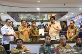 Menteri Dalam Negeri (Mendagri) Tito Karnavian (kedua kiri) bersama Menteri Perumahan dan Kawasan Permukiman (PKP) Maruarar Sirait (kedua kanan), Pj Gubernur Banten Ucok Abdulrauf Damenta(kiri), dan Pj Wali Kota Tangerang Nurdin (kanan) memberikan surat persetujuan bangunan gedung kepada warga saat meninjau layanan Persetujuan Bangunan Gedung (PBG) di Gedung Pusat Pemerintahan Kota Tangerang, Banten, Selasa (14/1/2025). Dalam kunjungannya Mendagri dan Menteri PKP meresmikan inovasi pelayanan PBG yang dapat memangkas waktu birokrasi dengan menerbitkan persetujuan bangunan gedung dalam waktu maksimal 10 jam di Mal Pelayanan Publik (MPP) Kota Tangerang. ANTARA FOTO/Sulthony Hasanuddin/gp