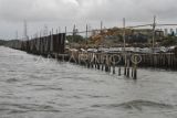 Sejumlah alat berat terparkir di samping pagar laut yang terpasang di kawasan pesisir Tarumajaya, Kabupaten Bekasi, Jawa Barat, Selasa (14/1/2025). Menurut nelayan setempat pemasangan pagar laut yang membentang sepanjang 2 km itu mengganggu lalu lintas kapal kecil dan berpotensi merusak ekosistem laut karena adanya pengerukan tanah. ANTARA FOTO/Fakhri Hermansyah/tom.