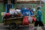 Petugas membawa limbah kardus dan botol plastik yang dikumpulkan warga menggunakan gerobak untuk dibawa menuju bank sampah di Desa Margagiri, Bojonegara, Kabupaten Serang, Banten, Rabu (15/1/2025). Daerah yang telah diresmikan sebagai desa wisata pada tahun 2024 dan dikelola oleh Badan Usaha Milik Desa (BUMDes) tersebut menawarkan eduwisata pertanian, perikanan, serta lingkungan hidup yang berfokus pada kebersihan kampung dan pengelolaan sampah. ANTARA FOTO/Angga Budhiyanto/gp