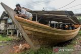 Pekerja menyelesaikan pembuatan perahu di Kasemen, Kota Serang, Banten, Kamis (16/1/2025). Perahu tersebut dijual dengan harga Rp30 juta - Rp500 juta tergantung ukuran gross tonnage (GT) dengan waktu pengerjaan selama empat hingga tujuh bulan. ANTARA FOTO/Putra M. Akbar/gp