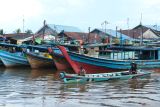 Destinasi wisata unggulan Desa Sungai Kakap. Dua warga menaiki perahu motor saat melewati barisan kapal penangkap ikan di Pelabuhan Sungai Kakap di Kabupaten Kubu Raya, Kalimantan Barat, Rabu (15/1/2025). Pelabuhan Sungai Kakap yang merupakan pusat pendaratan ikan dari kapal nelayan tradisional yang menjaring hasil laut di Natuna dan sekitarnya tersebut adalah salah satu destinasi unggulan wisata Desa Sungai Kakap. ANTARA FOTO/Jessica Wuysang/rwa.Antara Foto/Jessica Wuysang (Antara Foto/Jessica Wuysang)