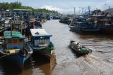 Destinasi wisata unggulan Sungai Kakap. Warga menaiki perahu motor saat melewati barisan kapal penangkap ikan di Pelabuhan Sungai Kakap di Kabupaten Kubu Raya, Kalimantan Barat, Rabu (15/1/2025). Pelabuhan Sungai Kakap yang merupakan pusat pendaratan ikan dari kapal nelayan tradisional yang menjaring hasil laut di Natuna dan sekitarnya tersebut adalah salah satu destinasi unggulan wisata Desa Sungai Kakap. ANTARA FOTO/Jessica Wuysang/rwa.Antara Foto/Jessica Wuysang (Antara Foto/Jessica Wuysang)