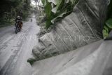 Pengendara sepeda motor melintas di jalan umum yang tertutup abu vulkanik dampak erupsi Gunung Ibu di Desa Tobaro, Kabupaten Halmahera Barat, Maluku Utara,Rabu (15/1/2025). Erupsi Gunung Ibu pada Rabu (15/1) pukul 07.11 WIT dengan semburan abu vulkanik setinggi 4.000 dari atas puncak menyebabkan sejumlah desa di Kecamatan Ibu Utara mengalami hujan abu, sementara gunung tersebut masih menunjukkan peningkatan aktivitas dan PVMBG menaikan status Gunung Ibu dari Siaga Level III menjadi Awas Level IV. ANTARA FOTO/Andri Saputra/rwa.