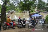 Pengendara roda dua antre menaiki perahu eretan menyeberangi sungai Ciujung di Kragilan, Kabupaten Serang, Banten, Senin (20/1/2025). Warga setempat terpaksa menggunakan perahu eretan sebagai moda penyeberangan untuk melintasi sungai Ciujung guna mempersingkat jarak tempuh karena tidak adanya akses jembatan penyeberangan di wilayah tersebut dengan tarif Rp2.000. ANTARA FOTO/Muhammad Bagus Khoirunas/gp