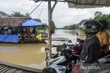 Pengendara roda dua menaiki perahu eretan menyeberangi sungai Ciujung di Kragilan, Kabupaten Serang, Banten, Senin (20/1/2025). Warga setempat terpaksa menggunakan perahu eretan sebagai moda penyeberangan untuk melintasi sungai Ciujung guna mempersingkat jarak tempuh karena tidak adanya akses jembatan penyeberangan di wilayah tersebut dengan tarif Rp2.000. ANTARA FOTO/Muhammad Bagus Khoirunas/gp