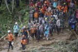 Relawan bersama anggota TNI dan Polri mengevakuasi jenazah korban tanah longsor di Desa Kasimpar di Kecamatan Petungkriyono, Kabupaten Pekalongan, Jawa Tengah, Kamis (23/1/2025). Berdasarkan data posko lapangan, pada hari ketiga pencaria korban yang dilakukan Basarnas, TNI, Polri, dan relawan berhasil menemukan satu korban meninggal dunia atas nama Diyatno di titik sekitar rumah kediaman sekretaris desa yang terdampak tanah longsor yang kemudian akan diserahkan ke pihak keluarga, sementara total korban meninggal dunia tercatat 22 orang, luka-luka 13, dan laporan orang hilang sebanyak empat orang. ANTARA FOTO/Harviyan Perdana Putra/tom.