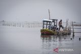 Nelayan turun dari kapal yang bersandar di dekat pagar laut di Desa Kohod, Kabupaten Tangerang, Banten, Jumat (24/1/2025). Kementerian Agraria dan Tata Ruang/Badan Pertanahan Negara membatalkan sebanyak 50 Sertifikat Hak Guna Bangunan (SHGB) dan Sertifikat Hak Milik (SHM) yang berada di desa tersebut sebagai tindak lanjut adanya pagar bambu ilegal di kawasan laut Kabupaten Tangerang. ANTARA FOTO/Putra M. Akbar/gp