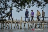 Menteri Agraria dan Tata Ruang/Kepala Badan Pertanahan Nasional (ATR/BPN) Nusron Wahid (kedua kiri) berjalan melewati jembatan di Pantai Anom, Desa Kohod, Kabupaten Tangerang, Banten, Jumat (24/1/2025). Pada kunjungan tersebut Menteri ATR/BPN meninjau pagar laut yang terpasang di sekitar perairan kawasan Pantai Anom dan mendengarkan aspirasi masyarakat pesisir yang terdampak. ANTARA FOTO/Putra M. Akbar/gp