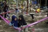 Sejumlah anak bersantai di tempat tidur gantung (hammock) di Hutan Jati Raya Sindang Asih, Kabupaten Tangerang, Banten, Sabtu (25/1/2025). Destinasi wisata alam dengan memanfaatkan hutan pohon jati yang dikelola swadaya oleh warga desa setempat  tersebut menyediakan wahana permainan anak, tempat tidur gantung, motor ATV dan spot foto. ANTARA FOTO/Putra M. Akbar/gp